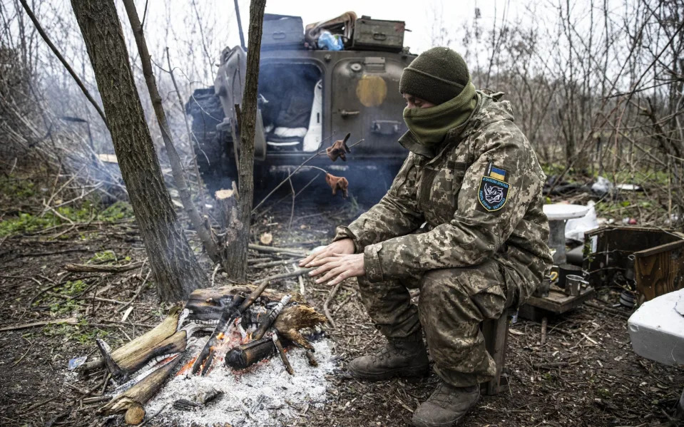  A Ukrainian soldier tries to warm up on the frontline, in Donetsk Oblast - Anadolu Agency