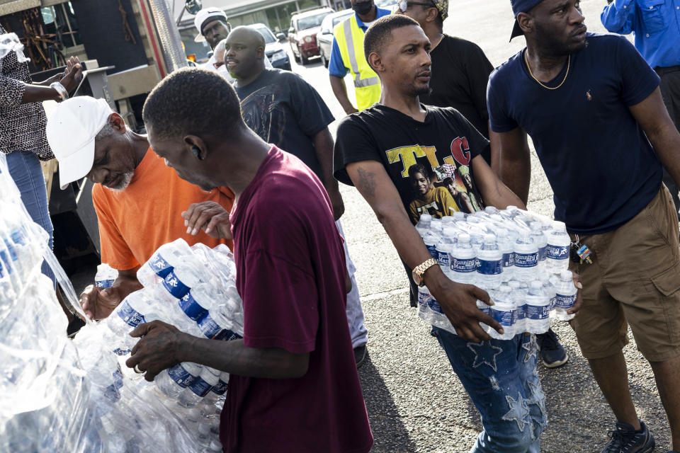 Cases of bottled water are handed out at a Mississippi Rapid Response Coalition distribution site (Brad Vest / Getty Images)