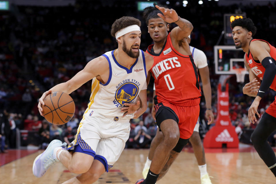 Golden State Warriors guard Klay Thompson (11) drives into Houston Rockets guard Jalen Green (0) during the first half of an NBA basketball game Monday, Jan. 31, 2022, in Houston. (AP Photo/Michael Wyke)