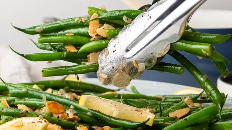 green beans held in tongs