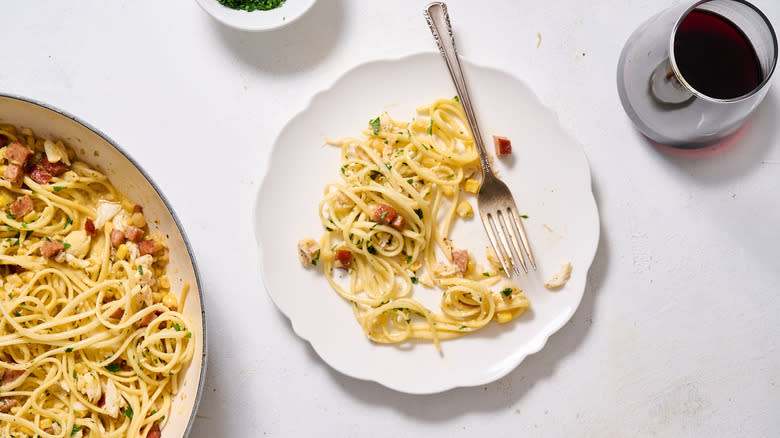 crab and sausage carbonara pasta served on white plate