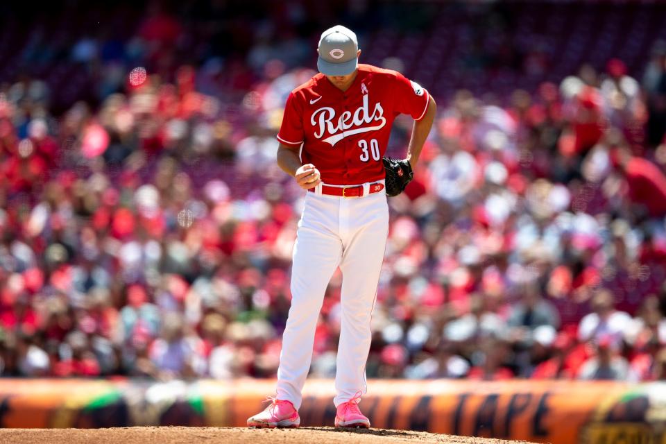 Cincinnati Reds starting pitcher Tyler Mahle (30) looks down in between pitches in the second inning of the MLB game between the Cincinnati Reds and the Pittsburgh Pirates at Great American Ball Park in Cincinnati on Sunday, May 8, 2022.