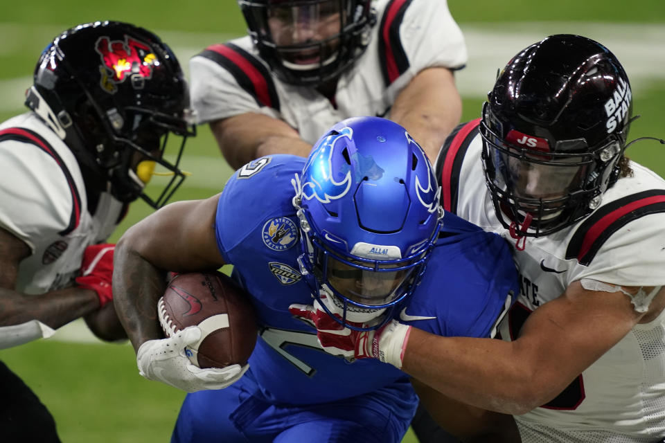 Buffalo running back Ron Cook Jr. (2) is tackled by Ball State's Tye Evans during the second half of the Mid-American Conference championship NCAA college football game, Friday, Dec. 18, 2020 in Detroit. (AP Photo/Carlos Osorio)