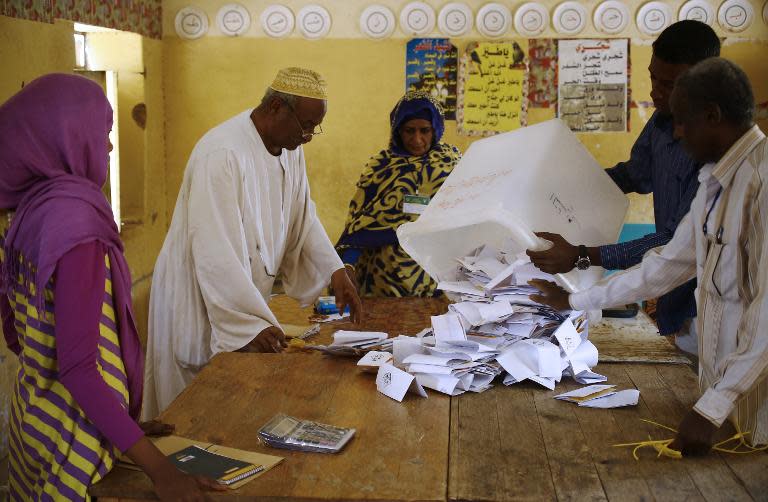 Polling station staff members empty a ballot box to count votes at a polling station in the Sudanese capital, Khartoum, on April 17, 2015