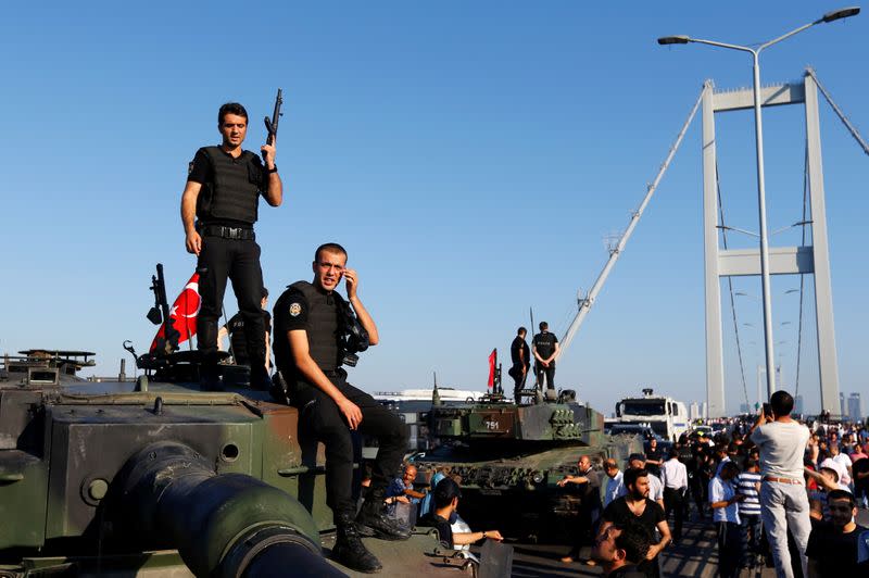 FILE PHOTO: Policemen stand atop military armored vehicles after troops involved in the coup surrendered on the Bosphorus Bridge in Istanbul