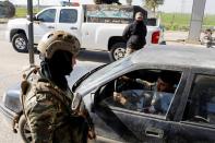Christian militia check a vehicle at a gate of Christian town of Hamdaniya