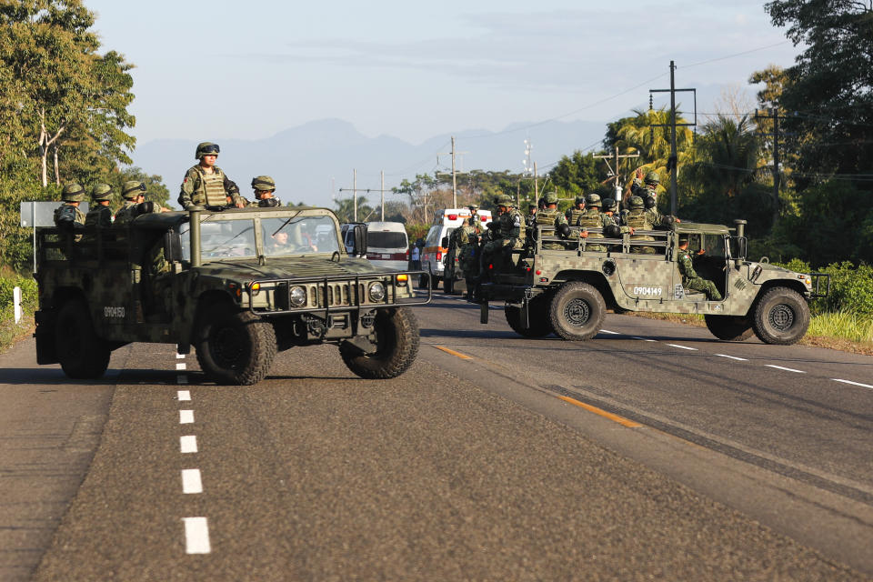 Mexican National Guards block a highway in Ciudad Hidalgo, Mexico after a group of Central American migrants crossed the border from Guatemala to Mexico, Thursday, Jan. 23, 2020. Hundreds of Central American migrants crossed the river into Mexico from Guatemala Thursday after a days-long standoff with security forces. (AP Photo/Marco Ugarte)