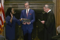 In this image from video provided by the Supreme Court, Chief Justice of the United States John Roberts administers the Constitutional Oath to Ketanji Brown Jackson as her husband Patrick Jackson holds the Bible at the Supreme Court in Washington, Thursday, June 30, 2022. (Supreme Court via AP)