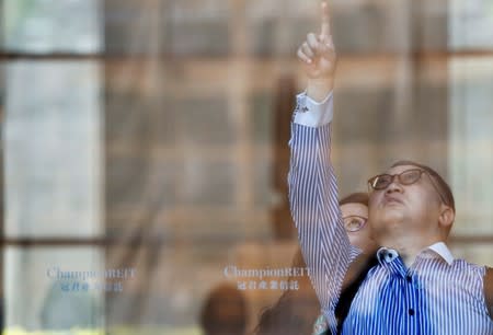 People watch the French urban climber Alain Robert climb the Cheung Kong Center building in Hong Kong