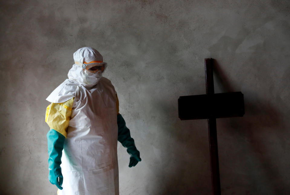 Un trabajador pasa junto a una cruz en un funeral por un fallecido por ébola (REUTERS/Goran Tomasevic).