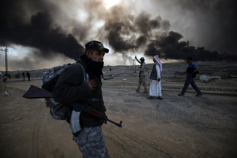 A Sunni fighter from the Popular Mobilization Forces pictured east of Mosul on October 22, 2016, as displaced Iraqi families flee during an operation to retake the strategic city from IS group jihadists