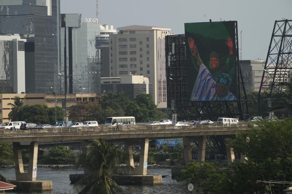 Cars drive past an electronic campaign billboards of Bola Ahmed Tinubu, presidential candidate of the All Progressives Congress, Nigeria ruling party in Lagos Nigeria, Tuesday, Feb. 7, 2023. Fueled by high unemployment and growing insecurity, younger Nigerians are mobilizing in record numbers to take part in this month's presidential election. (AP Photo/Sunday Alamba)