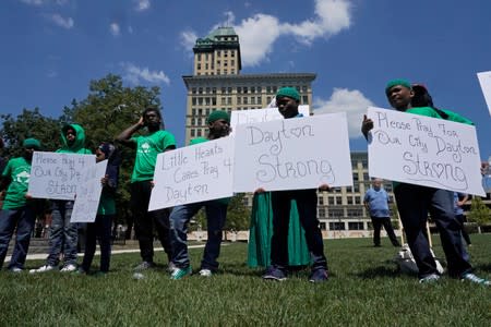 Young people gather holding signs during a vigil service, after a mass shooting in Dayton