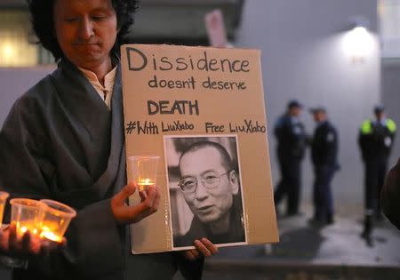 Members of the Australian Tibetan community stand together as they hold placards during a candlelight vigil for the Chinese Nobel Peace Prize-winning dissident Liu Xiaobo outside the Chinese consulate in Sydney, Australia, July 12, 2017. REUTERS/Steven Saphore