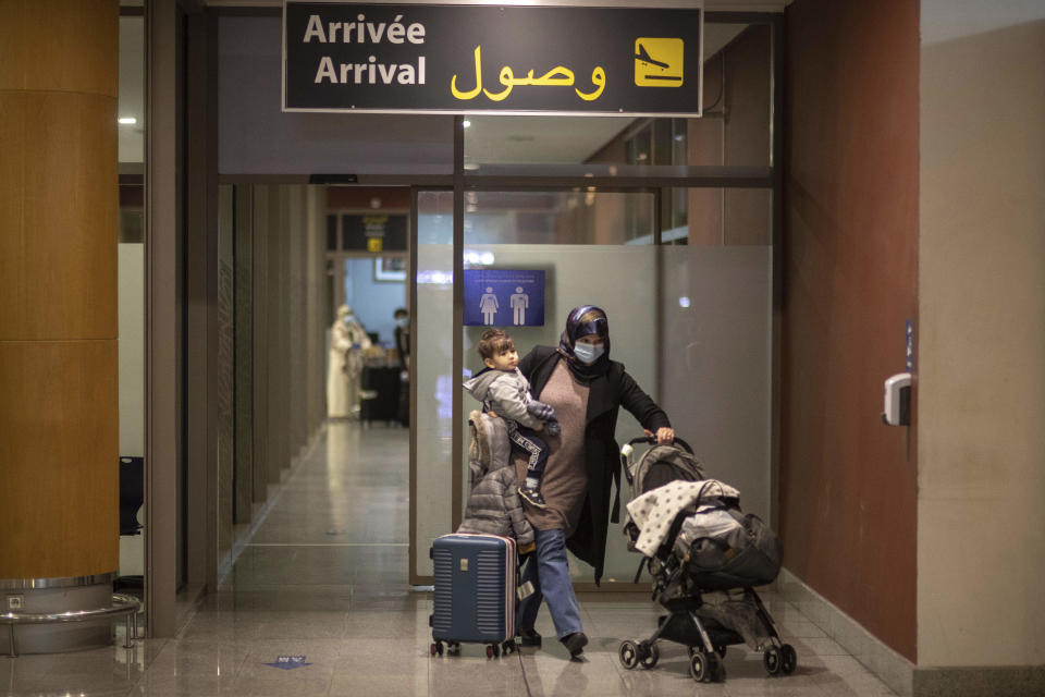 A traveler on the last flight to Morocco before flights are suspended, arrives at a terminal in Rabat airport, Morocco, Monday, Nov. 29, 2021. Morocco announced it would suspend all incoming air travel from around the world starting Monday for two weeks because of the rapid spread of the new omicron variant, the government's committee in charge of monitoring COVID-19 announced Sunday. (AP Photo/Mosa'ab Elshamy)