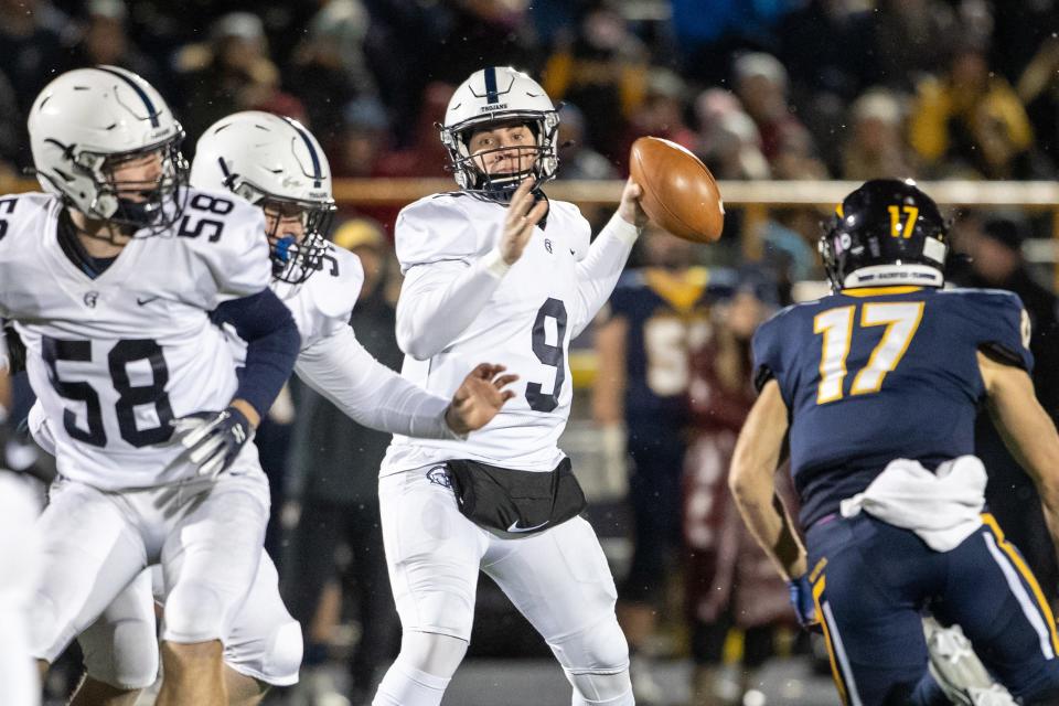 McDowell's Ben Moore (9) throws a pass in front of Mt. Lebanon's Tommy Boehner (17) during the first quarter of a PIAA Class 6A quarterfinal football game, Nov. 26, 2021 at Mt. Lebanon High School in Pittsburgh. The Trojans lost to the Blue Devils 47-14.