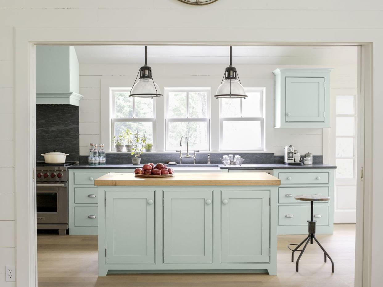 a kitchen with mint green cabinets