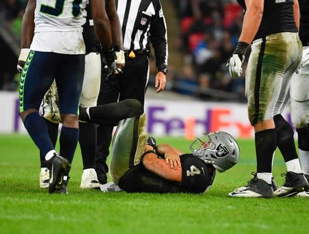 Oct 14, 2018; London, United Kingdom; Oakland Raiders quarterback Derek Carr (4) reacts after he was sacked during the third quarter of the game between the Oakland Raiders and the Seattle Seahawks during an International Series game at Wembley Stadium. Mandatory Credit: Steve Flynn-USA TODAY Sports