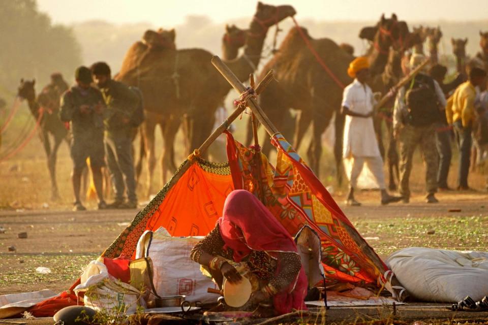 3 novembre 2022 : Un villageois prépare du pain roti sur le site de la foire annuelle aux chameaux à Pushkar, dans l'État désertique indien du Rajasthan (AFP via Getty Images)