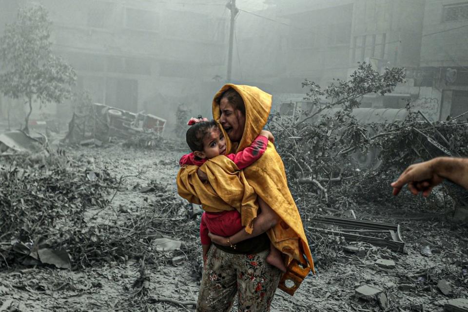 A woman holding a girl reacts after Israeli airstrikes hit the Ridwan neighborhood of Gaza City on Oct. 23.<span class="copyright">Ali Jadallah—Anadolu/Getty Images</span>