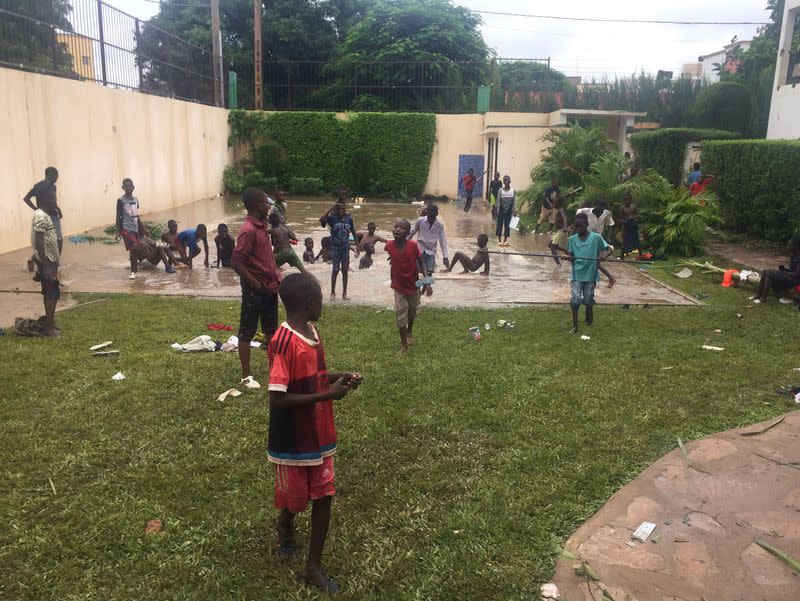 People are seen outside the ransacked house of Karim Keita in Bamako