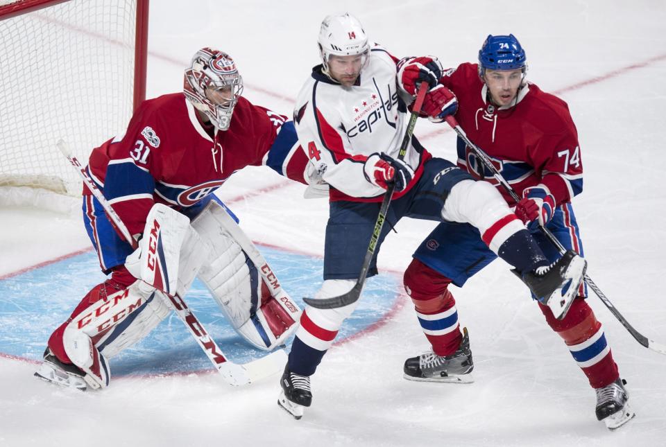 Washington Capitals right wing Justin Williams (14) is taken out from in front of Montreal Canadiens goalie Carey Price (31) by Canadiens defenseman Alexei Emelin (74) during the second period of an NHL hockey game Monday, Jan. 9, 2017, in Montreal. (Paul Chiasson/The Canadian Press via AP)
