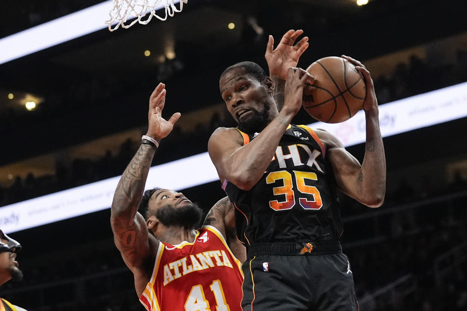 Phoenix Suns forward Kevin Durant (35) grabs a rebound in front of Atlanta Hawks forward Saddiq Bey (41) in the first half of an NBA basketball game Friday, Feb. 2, 2024, in Atlanta. (AP Photo/John Bazemore)