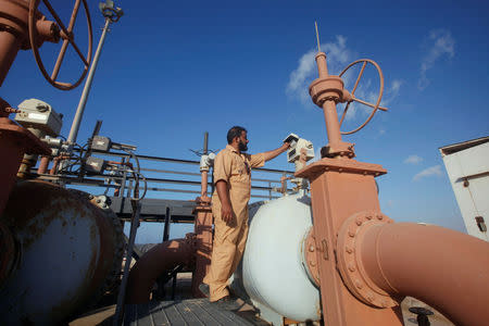 FILE PHOTO: Khalifa Mohamed Mazk inspects a pipeline at Marsa al Hariga oil port in the city of Tobruk, approximately 1,500 km (932 miles) east of Tripoli August 20, 2013. REUTERS/Ismail Zitouny/File Photo
