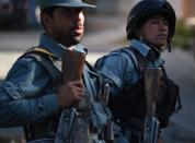 Two Afghan policemen keep watch near the gates of the Heetal Hotel in Kabul, on May 27, 2015