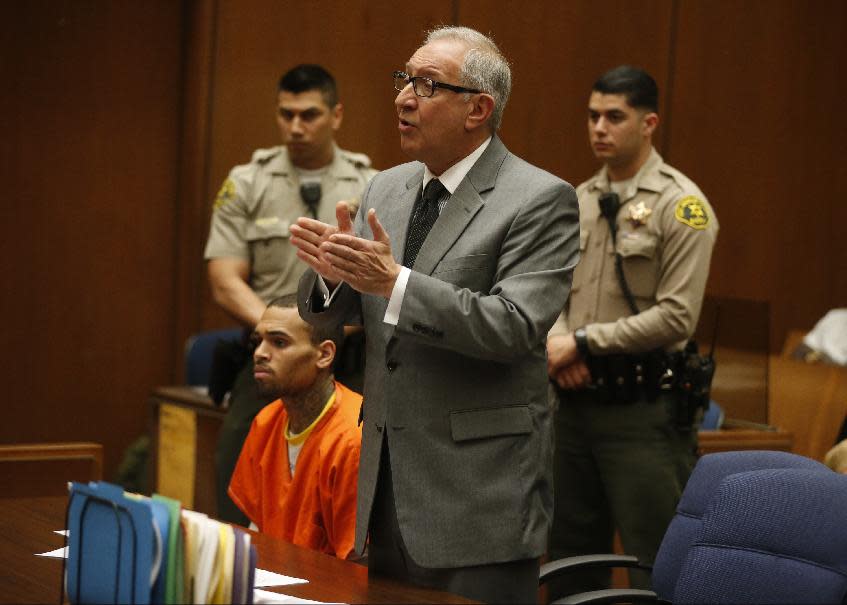 R&B singer Chris Brown, left, appears in Los Angeles Superior Court with his attorney Mark Geragos, on Monday, March 17, 2014. Brown will spend another month in jail after a judge said Monday he was told the singer made troubling comments in rehab about being good at using guns and knives. The singer was arrested on Friday, March 14, 2014, after he was dismissed from a Malibu facility where he was receiving treatment for anger management, substance abuse and issues related to bipolar disorder. (AP Photo/Lucy Nicholson, Pool)