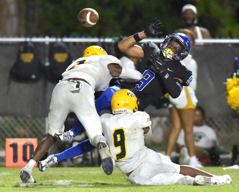 Trinity Christian receiver Kyle Boylston (9) jumps for a pass, broken up by Ed White's Joshua Patterson (2) and Addison Powell (9).