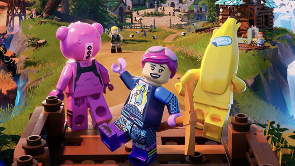  Three Lego Fortnite characters stand looking out over its vast open world. The one in the centre waves at the camera. 