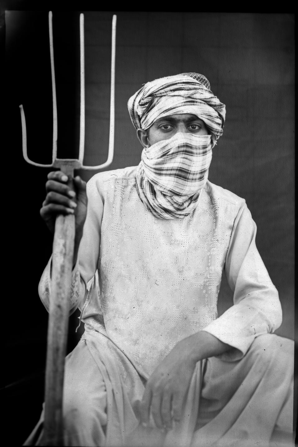 Shahram, 18, poses for a portrait while taking a break from working in a wheat field on the outskirts of Herat, Afghanistan, Saturday, June 3, 2023. (AP Photo/Rodrigo Abd)