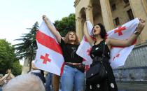 Opposition demonstrators wave Georgian national flags as they gather in front of the Georgian Parliament building in Tbilisi, Georgia, Saturday, June 22, 2019. Demonstrators denounced the government Friday as overly friendly to Russia and calling for a snap parliamentary election. (AP Photo/Shakh Aivazov)