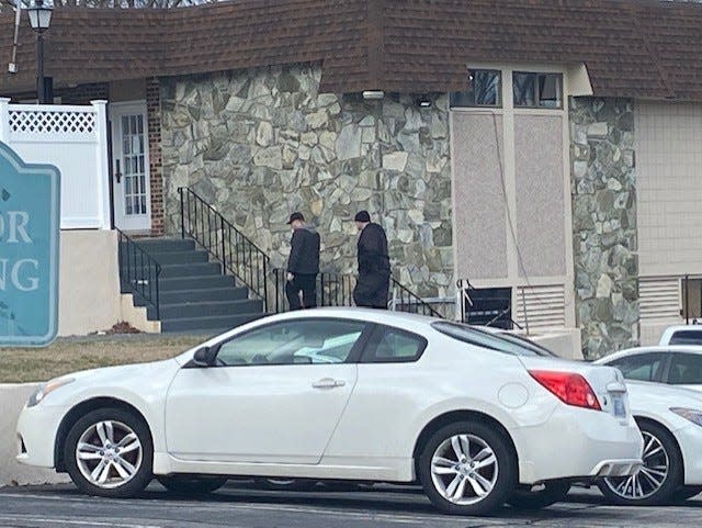 Investigators access a management office at the clubhouse of Tanglewood Village in West Warwick.