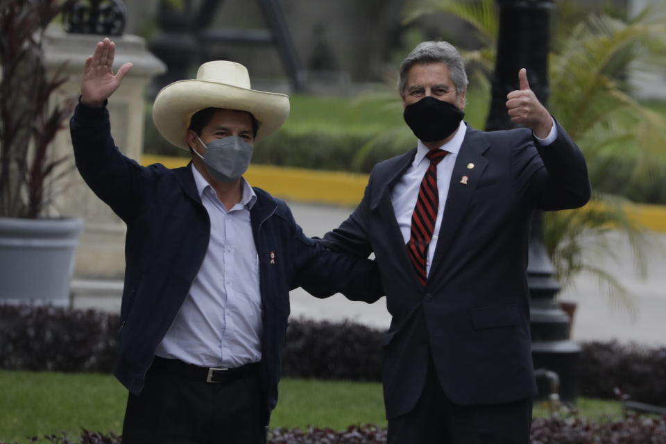 President-elect Pedro Castillo, left, poses for a photo with interim President Francisco Sagasti at the government palace after a transition meeting, in Lima, Peru, Wednesday, July 21, 2021. Castillo will be sworn in on July 28. (AP Photo/Gudalupe Pardo)