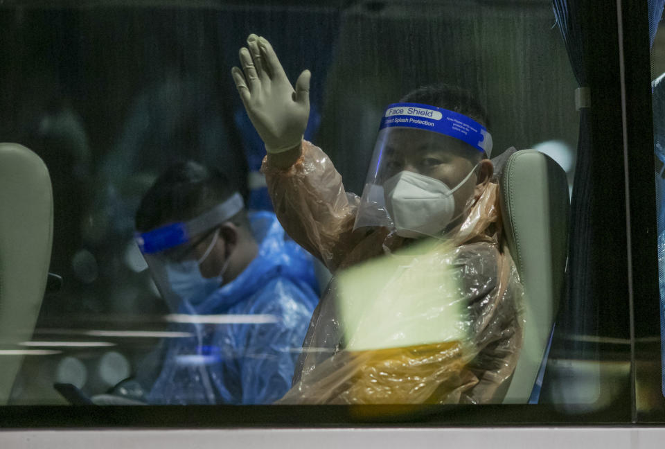 A Chinese tourist from Shanghai who arrived on a special tourist visa, waves from a transit bus at Suvarnabhumi airport in Bangkok, Thailand, Tuesday, Oct. 20, 2020. Thailand on Tuesday took a modest step toward reviving its coronavirus-battered tourist industry by welcoming 39 visitors who flew in from Shanghai, the first such arrival since normal traveler arrivals were banned almost seven months ago. (AP Photo/Wason Wanichakorn)