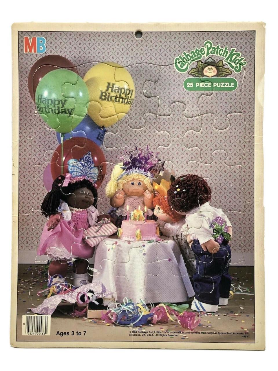A puzzle of Cabbage Patch Kids dolls blowing candles on a birthday cake