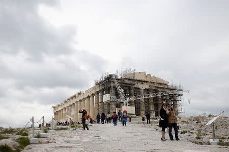 Tourists take a selfie in front of the temple of Parthenon atop Acropolis hill in Athens February 22, 2015. REUTERS/Kostas Tsironis