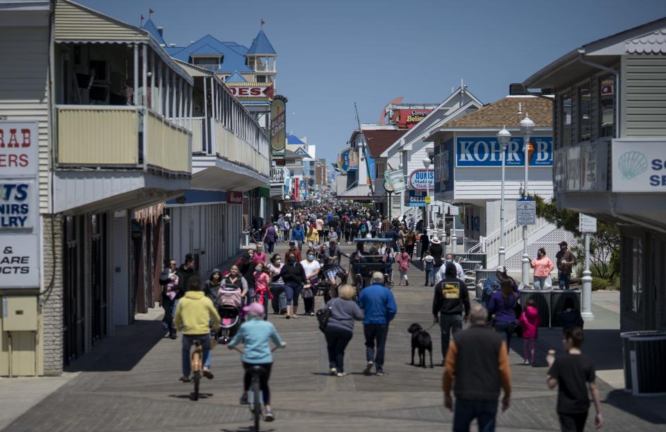 People walk on the boardwalk in Ocean City, Md., on May 10 as the area reopens from coronavirus shutdowns. A popular summer tourist destination, Ocean City reopened the beach but town officials said the initial reopening was designed primarily for locals.