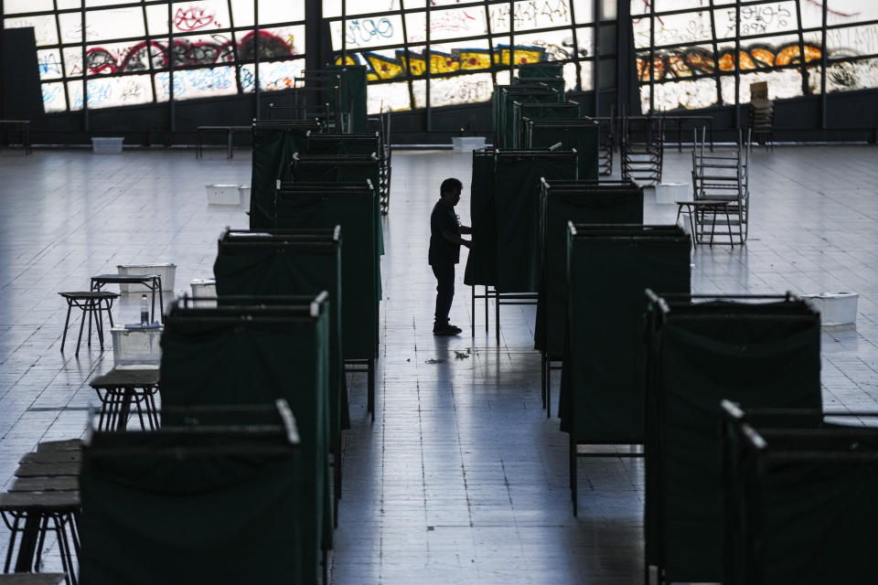 Un trabajador electoral prepara un centro cultural en la antigua estación de tren de Mapocho para que sea un colegio electoral para el próximo plebiscito constitucional en Santiago, Chile, el viernes 15 de diciembre de 2023. (AP Foto/Esteban Félix)