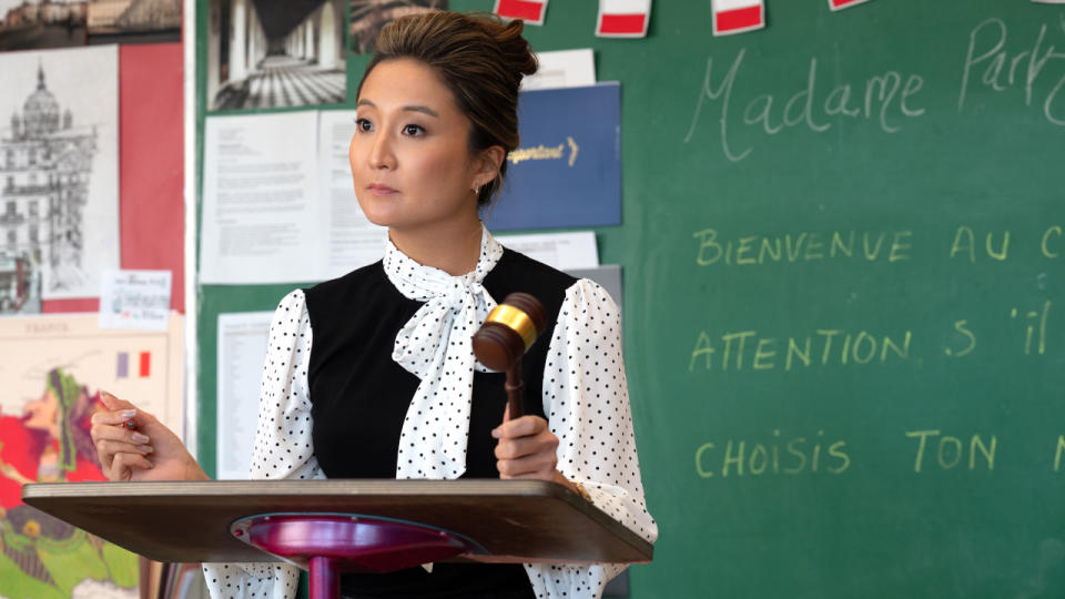 Ashley Park wields a gavel in her French class in Mean Girls.