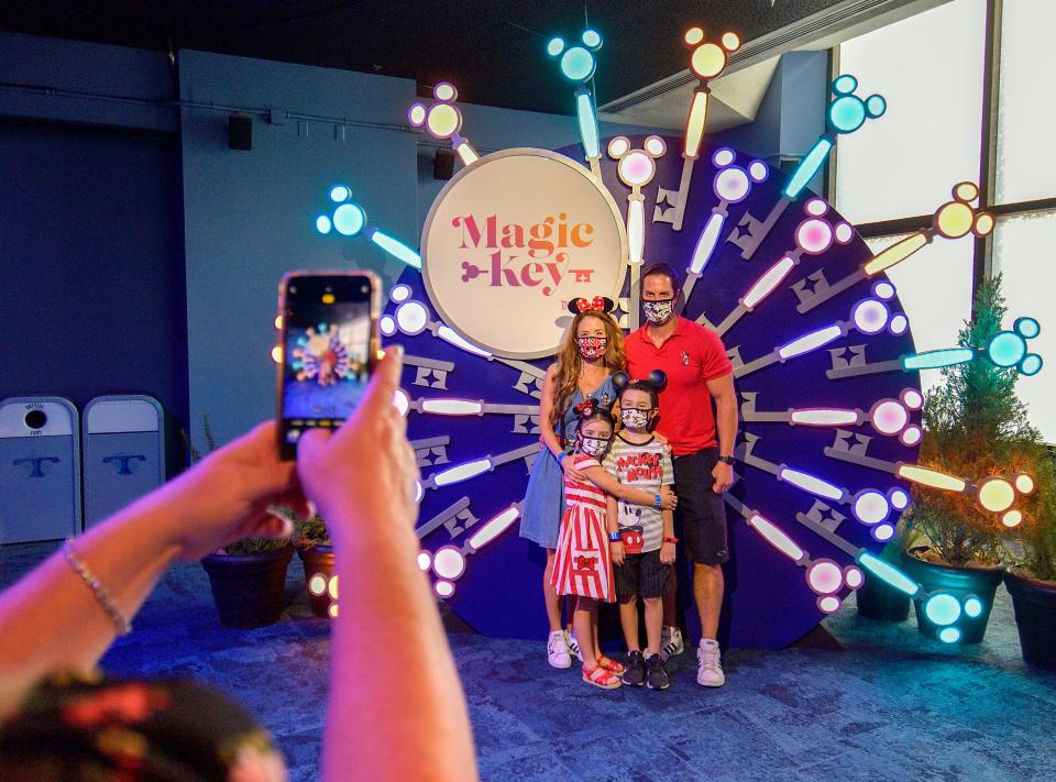 A family poses for a picture inside the Magic Key Starcade Experience at Disneyland.
