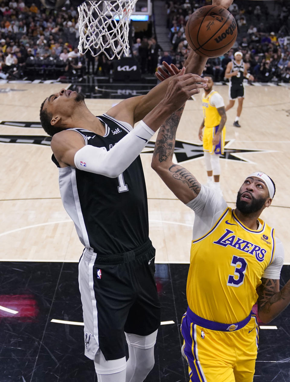 San Antonio Spurs center Victor Wembanyama (1) is fouled by Los Angeles Lakers forward Anthony Davis (3) as he tries to score during the first half of an NBA basketball game in San Antonio, Wednesday, Dec. 13, 2023. (AP Photo/Eric Gay)