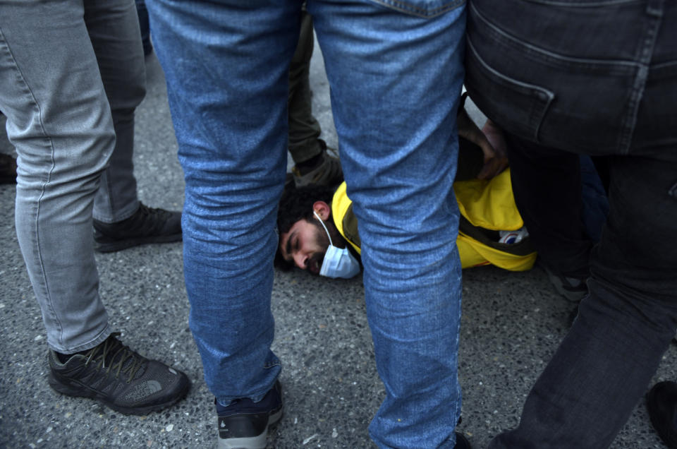 Turkish police officers arrest a youth during clashes with students of the Bogazici University protesting the appointment of a government loyalist to head their university, in Istanbul, Tuesday, Feb. 2, 2021. For weeks, students and faculty at Istanbul's prestigious Bogazici University have been protesting President Recep Tayyip Erdogan's appointment of Melih Bulu, a figure who has links to his ruling party, as the university's rector. They have been calling for Bulu's resignation and for the university to be allowed to elect its own president. (AP Photo/Omer Kuscu)