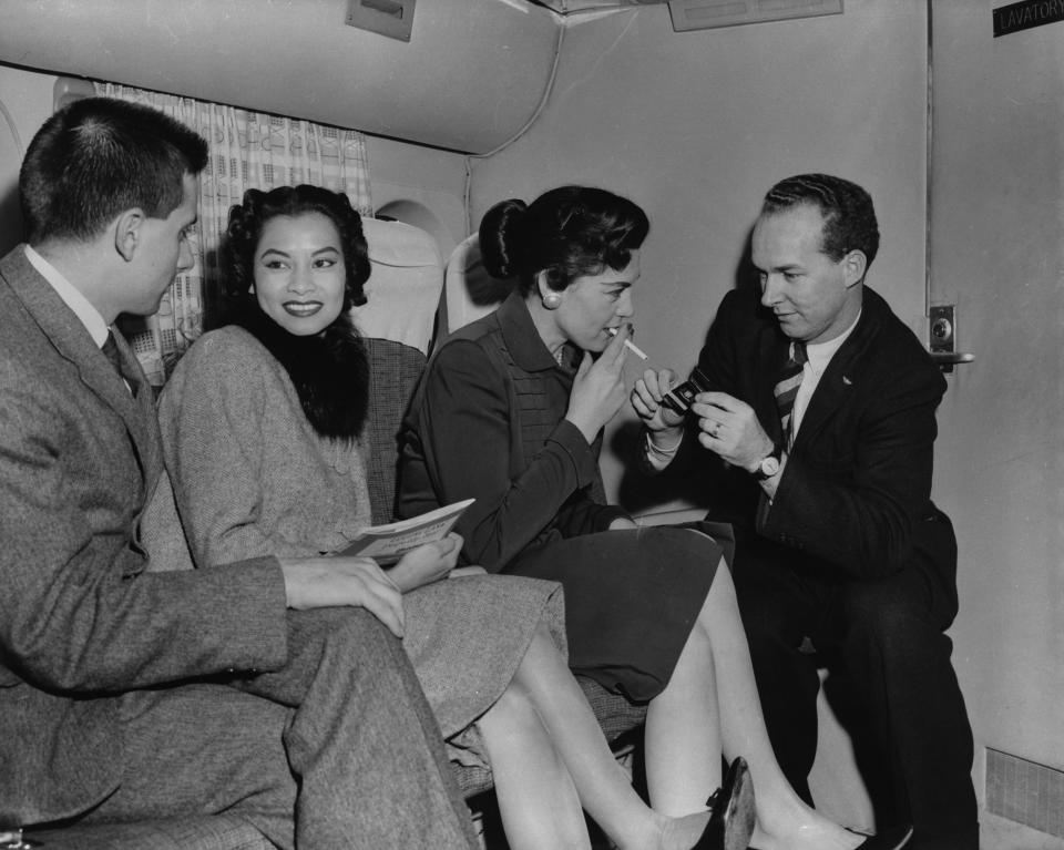 Passengers enjoy a relaxing smoke on a Transocean Air lines Boeing 377 Stratocruiser circa 1955.