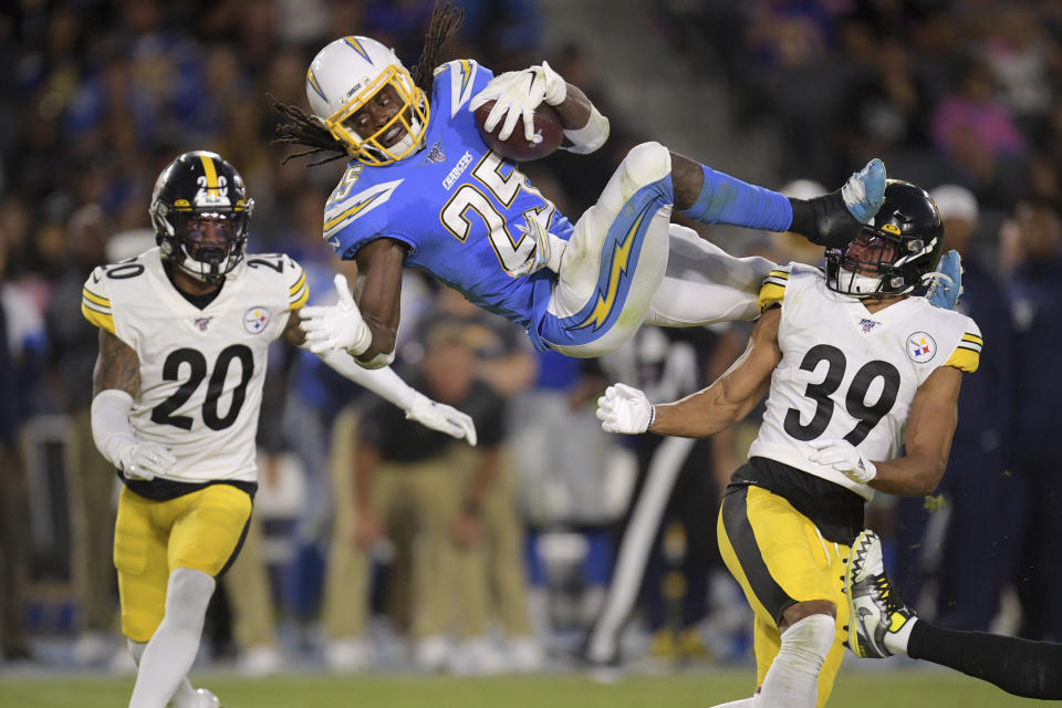 Los Angeles Chargers defensive back Rayshawn Jenkins, center, trips as he runs the ball past Pittsburgh Steelers cornerback Cameron Sutton, left, and lfree safety Minkah Fitzpatrick during the first half of an NFL football game, Sunday, Oct. 13, 2019, in Carson, Calif. (AP Photo/Kyusung Gong)