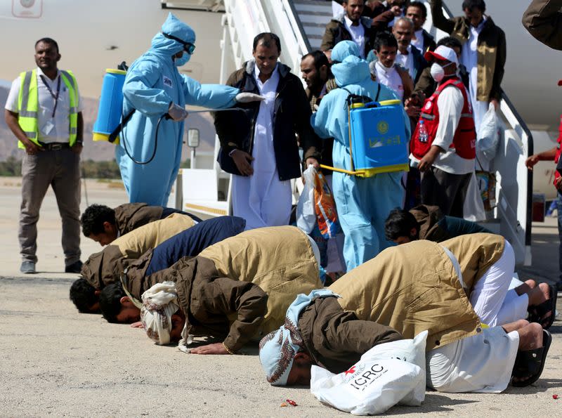 Freed Saudi-led coalition prisoners pray as they arrive after their release in a prisoner swap, at Sayoun airport