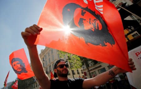 FILE PHOTO: Workers wave CGT labour union flags with an image of revolutionary hero Ernesto