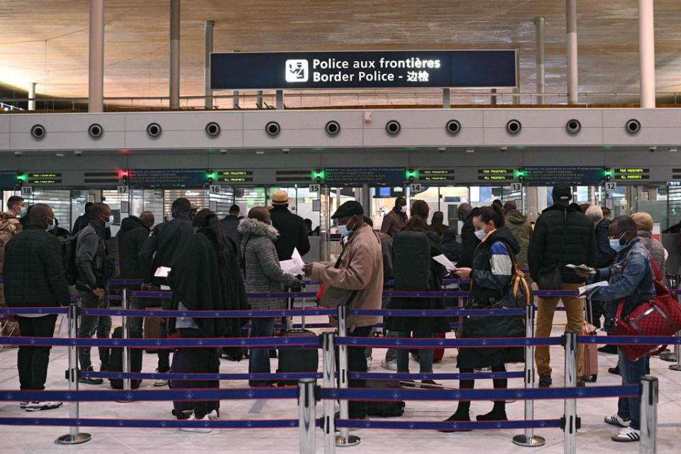 Masked passengers queuing at Charles-de-Gaulle international airport in Paris  (AFP via Getty Images)